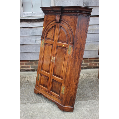 477 - An 18th century mahogany corner cupboard with dental cornice over arch top panelled doors, 38