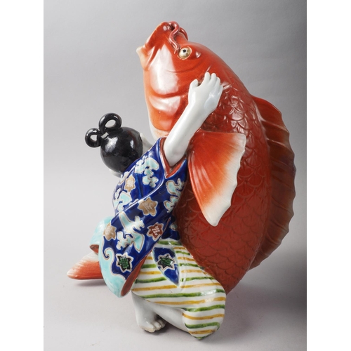 84 - A Chinese porcelain vase formed as a figure holding a carp, 11