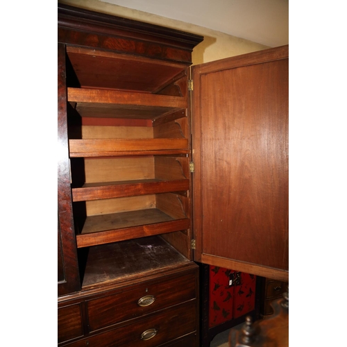 480 - An early 19th century figured mahogany linen press, the upper section fitted trays enclosed two pane... 