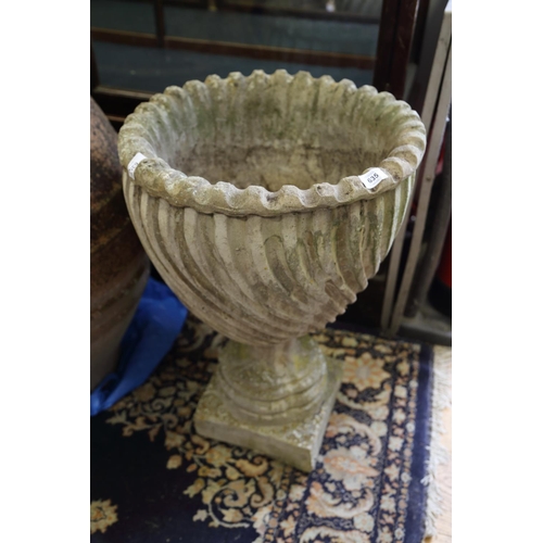 635 - A cast stone spiral fluted urn, on square base, 26