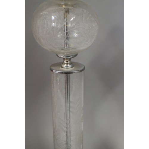 26 - A pair of clear glass table lamps with engraved leaf decoration, on square bases, 21 12