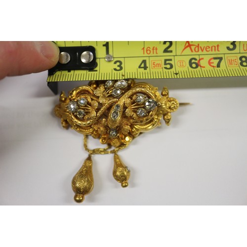 284 - A mid 19th century yellow metal scroll and leaf brooch set diamonds with two pendant drops, in conte... 