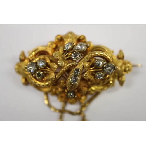 284 - A mid 19th century yellow metal scroll and leaf brooch set diamonds with two pendant drops, in conte... 