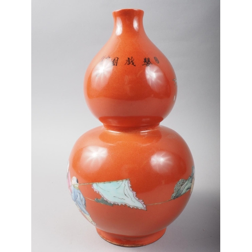 106 - A 20th century Chinese porcelain double gourd vase, decorated children playing on a coral powder gro... 