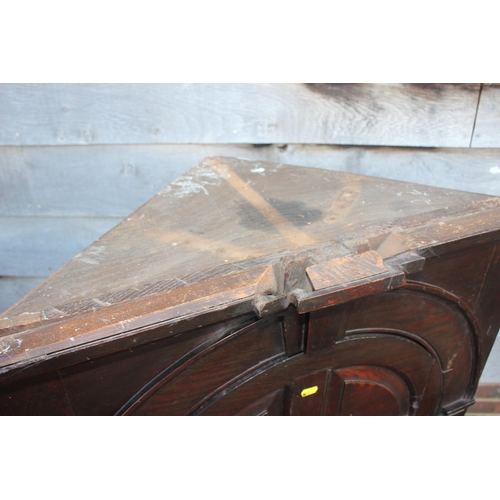 490 - An 18th century oak corner hanging cupboard, fitted shaped shelves enclosed arch top panel door, 33