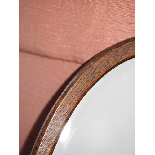 575 - An oak oval framed wall mirror with bevelled plate, 26 1/2