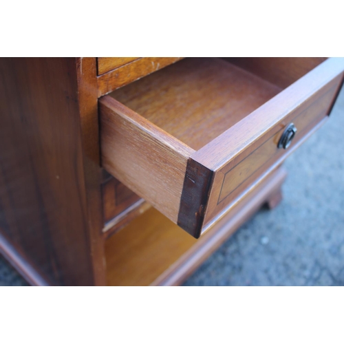 581 - A yew and banded low bedside chest, fitted slide over two short and one long drawer and recess, on s... 