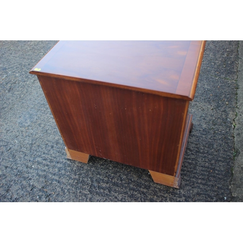 581 - A yew and banded low bedside chest, fitted slide over two short and one long drawer and recess, on s... 