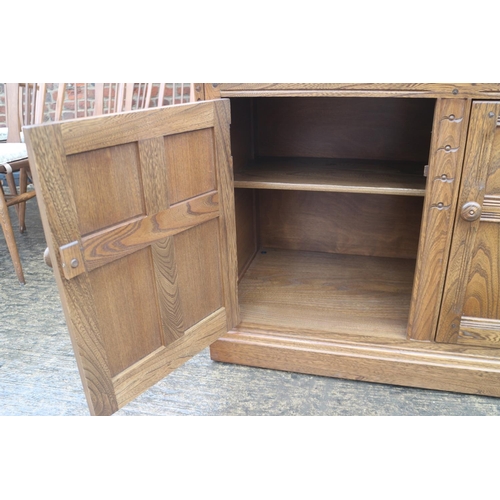 632 - An Ercol side cupboard enclosed two doors, on block base, 39