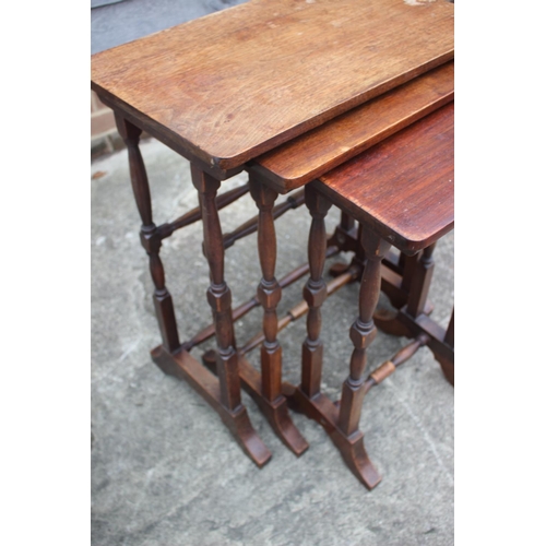 635 - A nest of three mahogany occasional tables, on turned and stretchered supports, largest 22