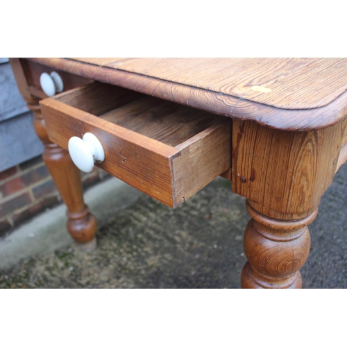 658 - A 19th century pitch pine kitchen table, fitted two drawers with ceramic knobs, on turned supports, ... 