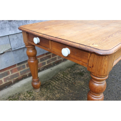 658 - A 19th century pitch pine kitchen table, fitted two drawers with ceramic knobs, on turned supports, ... 