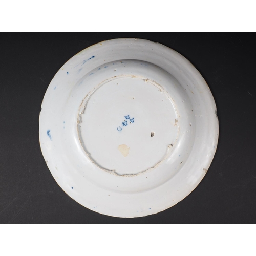 12 - An 18th century blue and white delft dish with central urn decoration, 9