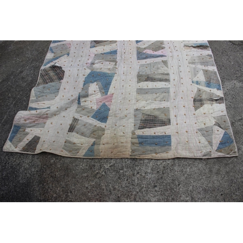 192 - An early 20th century patchwork quilt, in shades of blue, pink and cream, 72 1/2