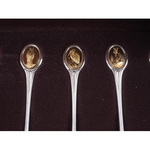 293 - A set of twelve silver and parcel gilt RSPB spoons, in fitted walnut case, 9.6oz troy approx