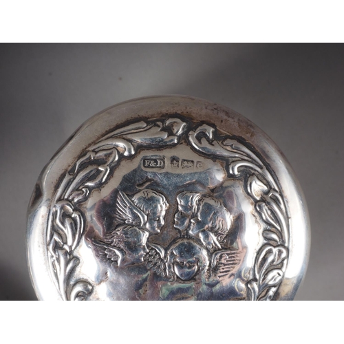 308 - An embossed silver backed hand mirror, a silver backed brush and four silver mounted toilet jars, va... 