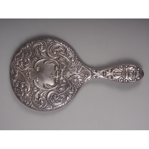 308 - An embossed silver backed hand mirror, a silver backed brush and four silver mounted toilet jars, va... 