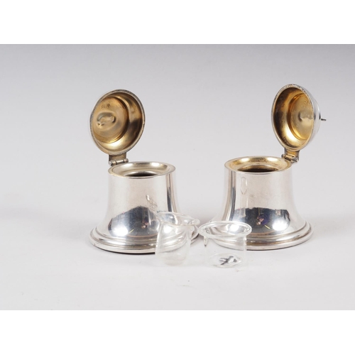 311 - A pair of silver bell-shaped desk inkwells with hinged lids and liners, 2 1/4