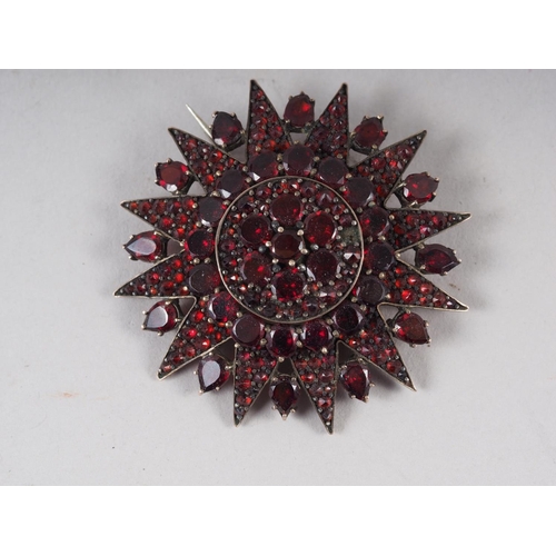 344 - An early 20th century Austro-Hungarian star burst brooch, set facetted garnets, mount unmarked, 44mm... 