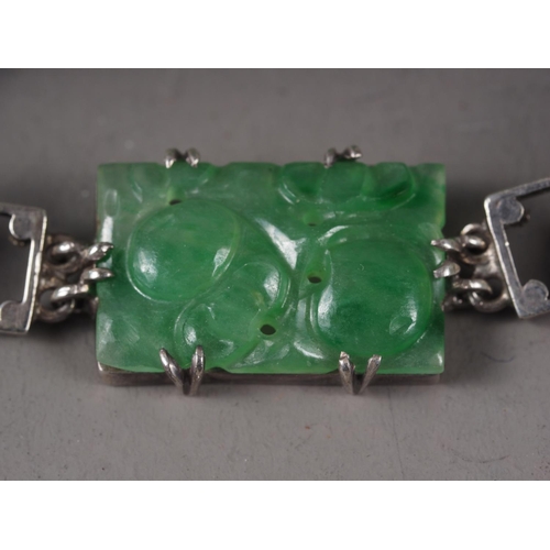 346 - A Chinese floral carved green jade and white metal mounted brooch and a similar bracelet