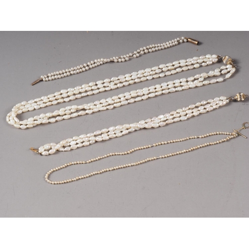 348 - A freshwater pearl three-strand necklace, a companion bracelet and two other pearl bracelets