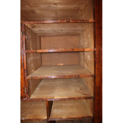 508 - An early Georgian figured walnut and feather banded cupboard of drawers, the upper section fitted tw... 