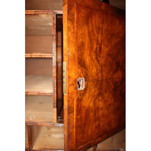 508 - An early Georgian figured walnut and feather banded cupboard of drawers, the upper section fitted tw... 