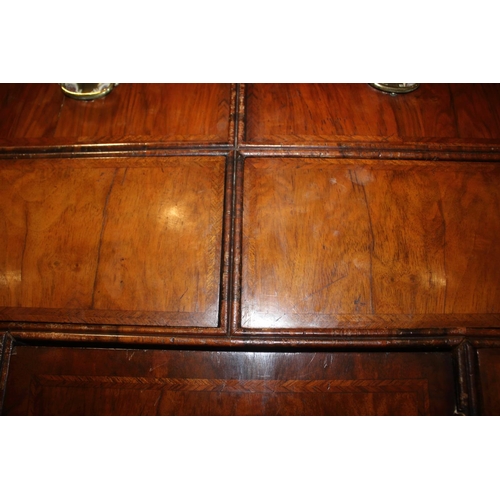 508 - An early Georgian figured walnut and feather banded cupboard of drawers, the upper section fitted tw... 