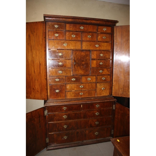 508 - An early Georgian figured walnut and feather banded cupboard of drawers, the upper section fitted tw... 