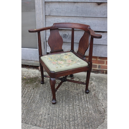 509 - A Georgian oak provincial corner elbow chair with needlework seat, on turned and cabriole supports