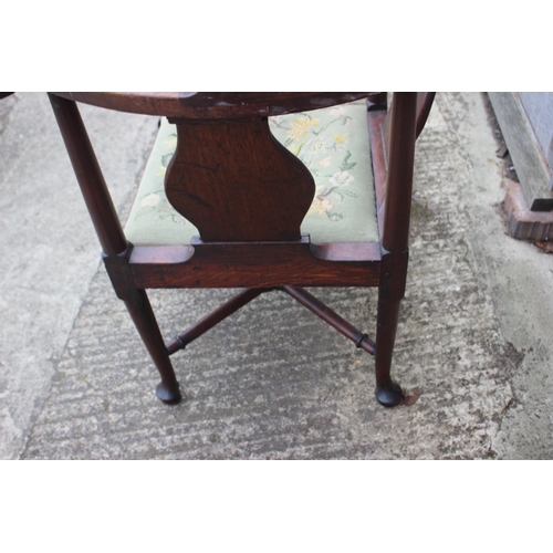 509 - A Georgian oak provincial corner elbow chair with needlework seat, on turned and cabriole supports