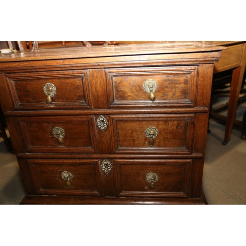 522 - An early 18th century oak chest of three long drawers with fielded panel fronts and brass drop handl... 