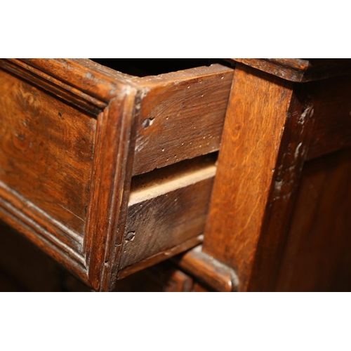 522 - An early 18th century oak chest of three long drawers with fielded panel fronts and brass drop handl... 