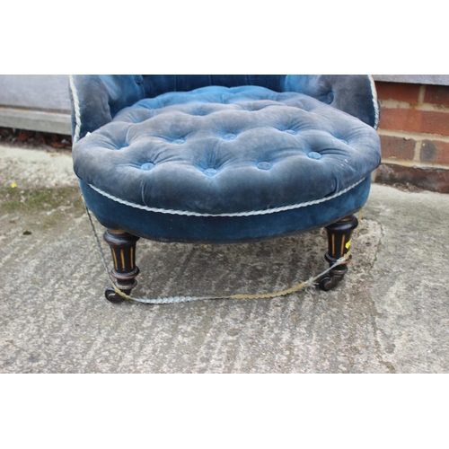 523 - A late 19th century low seat occasional chair, button upholstered in a blue velvet, on turned and ca... 