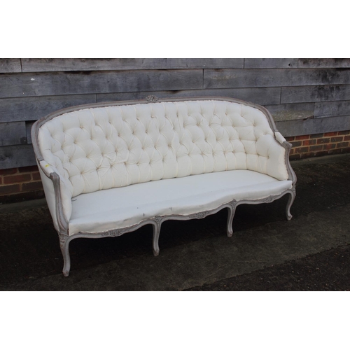 528 - A dove grey painted showframe settee of Louis XVI design, button upholstered in a cotton ticking wit... 