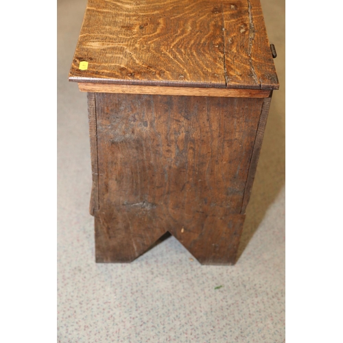 547 - An early 18th century oak coffer with chip carved front and hinged lid, on panel end supports, 39