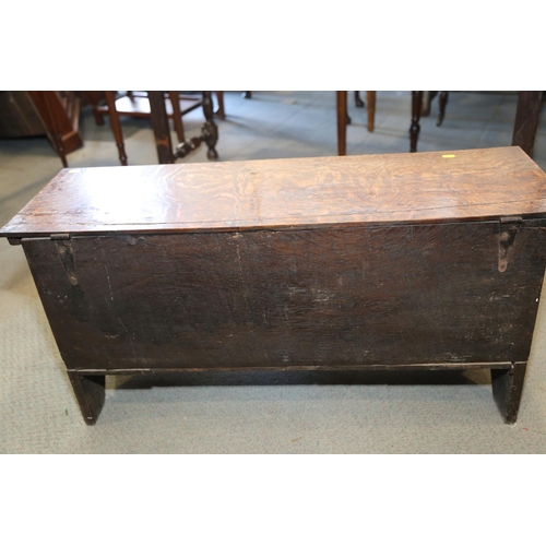 547 - An early 18th century oak coffer with chip carved front and hinged lid, on panel end supports, 39