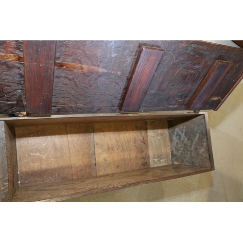 547 - An early 18th century oak coffer with chip carved front and hinged lid, on panel end supports, 39