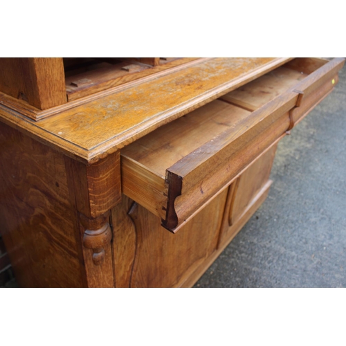 550 - A late 19th century light figured oak bookcase, the upper section fitted deep cornice over two leade... 