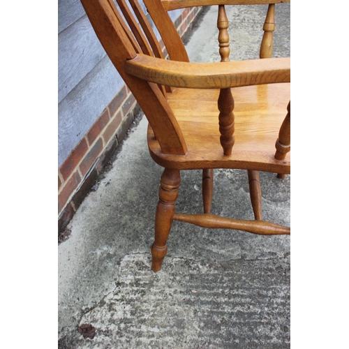 593 - A modern oak Windsor lath back elbow chair