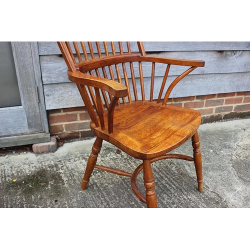 595 - A high spindle back Windsor elbow chair, on turned and crinoline stretchered supports