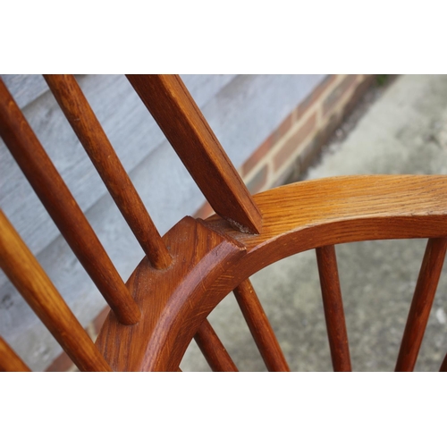 595 - A high spindle back Windsor elbow chair, on turned and crinoline stretchered supports