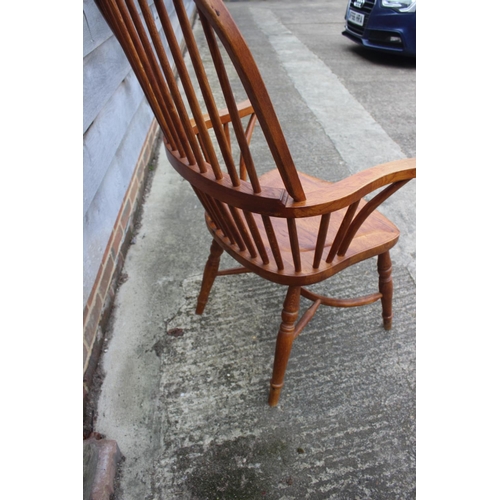 595 - A high spindle back Windsor elbow chair, on turned and crinoline stretchered supports