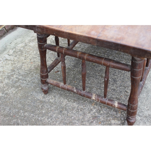 604 - An Arts & Crafts elm and ash low occasional table with spindle sides and turned supports, 42 1/2