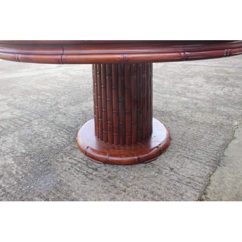 607 - A Chinese hardwood circular dining table, fitted four frieze drawers, on faux bamboo cluster column,... 