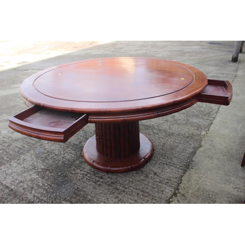 607 - A Chinese hardwood circular dining table, fitted four frieze drawers, on faux bamboo cluster column,... 