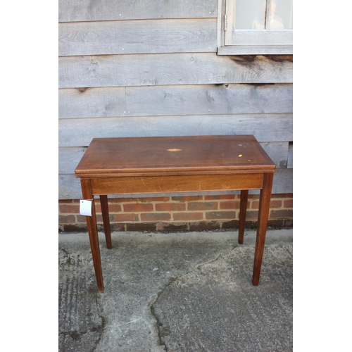 651 - A mahogany and banded and inlaid fold-over top card table, on square taper supports, 36