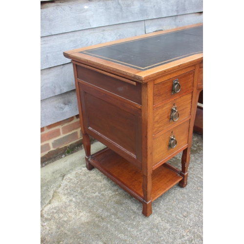 654 - An Arts & Crafts walnut break bowfront double pedestal desk with tooled lined top, fitted seven draw... 