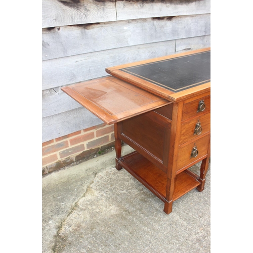 654 - An Arts & Crafts walnut break bowfront double pedestal desk with tooled lined top, fitted seven draw... 