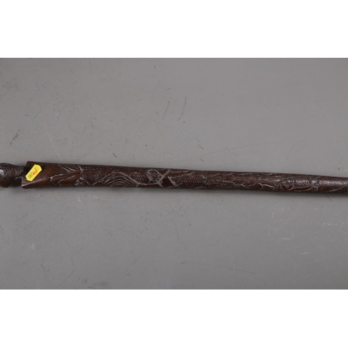 178 - An African (Ghana?) carved ironwood walking stick with loop handle, lizard and figure decorated shaf... 